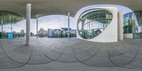 a view of a very modern building through a circle object in the center of a circular space