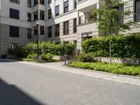 a row of houses next to a courtyard and landscaping area with stone path between buildings