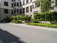 a row of houses next to a courtyard and landscaping area with stone path between buildings