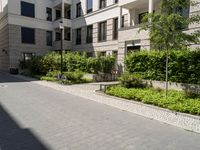 a row of houses next to a courtyard and landscaping area with stone path between buildings