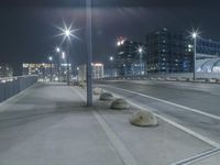 the empty city road is empty by the tall building in the background at night with light streaking on the buildings