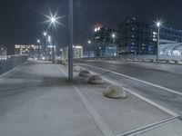 the empty city road is empty by the tall building in the background at night with light streaking on the buildings