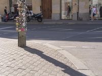 a street scene, with focus on the sign and pedestrians walking on the street in front