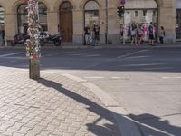 a street scene, with focus on the sign and pedestrians walking on the street in front