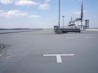 a boat is parked in an empty parking lot near an air port on the water
