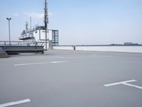 a boat is parked in an empty parking lot near an air port on the water