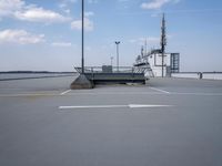 a boat is parked in an empty parking lot near an air port on the water