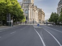 a empty empty street in front of buildings and trees in europe with no traffic or people