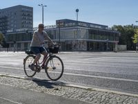 a woman rides her bike down the street in front of the library building in the city