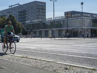 a woman rides her bike down the street in front of the library building in the city