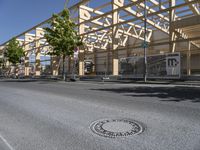 a city street with a train station over it's tracks and metal poles on the side