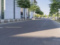 a person riding a skateboard on a city street with trees in the background and blue sky in the sky