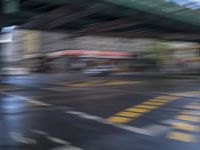 an image of a blurry picture of a city street with a street sign on the corner