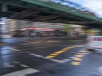 an image of a blurry picture of a city street with a street sign on the corner