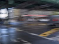 an image of a blurry picture of a city street with a street sign on the corner