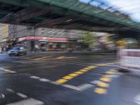 an image of a blurry picture of a city street with a street sign on the corner