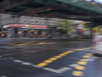 an image of a blurry picture of a city street with a street sign on the corner