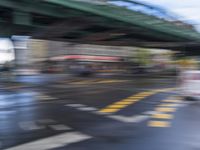 an image of a blurry picture of a city street with a street sign on the corner