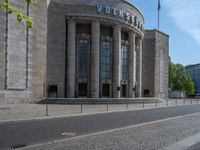 an entrance of a building with large columns and doors that spell out the word voltege