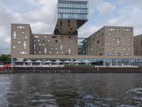 a view of a river near buildings on a cloudy day with blue sky above the water