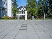 the block walkway has the two cement posts with the same square block that the sidewalk is located outside of