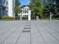 the block walkway has the two cement posts with the same square block that the sidewalk is located outside of