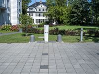 the block walkway has the two cement posts with the same square block that the sidewalk is located outside of