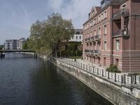 a very long waterway in front of an office building with a boat docked in it