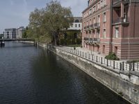 a very long waterway in front of an office building with a boat docked in it