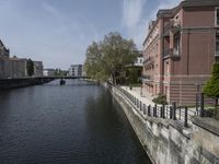 a very long waterway in front of an office building with a boat docked in it