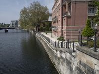 a very long waterway in front of an office building with a boat docked in it