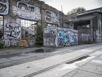 an abandoned railroad track in front of a graffiti covered building that says endmark raw