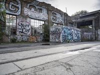 an abandoned railroad track in front of a graffiti covered building that says endmark raw