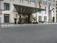 the large hotel entrance has lots of flags around it and signs on the side of the building