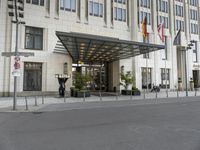 the large hotel entrance has lots of flags around it and signs on the side of the building