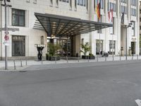 the large hotel entrance has lots of flags around it and signs on the side of the building