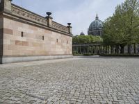 the courtyard of an old building with a clock tower in the background that has a circle - like pattern around the perimeter