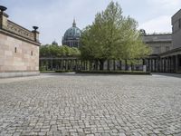 the courtyard of an old building with a clock tower in the background that has a circle - like pattern around the perimeter