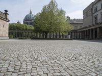 the courtyard of an old building with a clock tower in the background that has a circle - like pattern around the perimeter