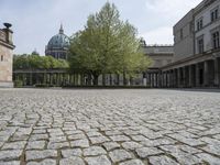 the courtyard of an old building with a clock tower in the background that has a circle - like pattern around the perimeter