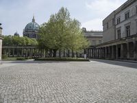 the courtyard of an old building with a clock tower in the background that has a circle - like pattern around the perimeter