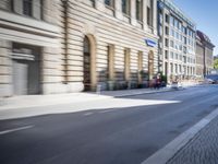 people walking and riding their bikes in the city streets are blurry as the car is passing by