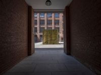 an empty hallway with brick walls and a glass window above it with a yellow curtain next to it