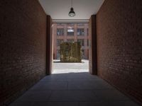 an empty hallway with brick walls and a glass window above it with a yellow curtain next to it