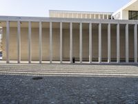 this is an empty building with columns in the center of it and some building in the background