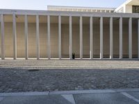 this is an empty building with columns in the center of it and some building in the background