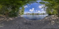 a fish eye view of a small pond on the shore of a lake with no waves