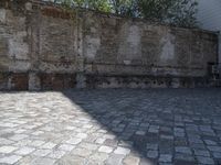 a person that is standing next to a wall with a skateboard on it in the pavement