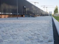 a brick building with glass windows and sidewalk leading to it and a black fire hydrant