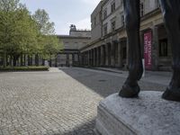 there is a horse statue next to some buildings and cobblestones in the street